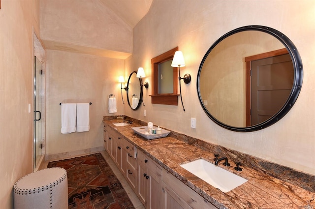 bathroom with tile flooring, double sink vanity, lofted ceiling, and a shower with door