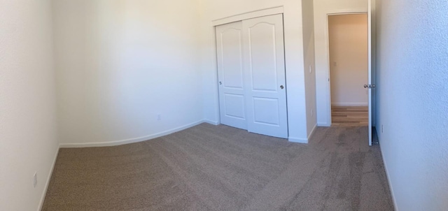 unfurnished bedroom with a closet and dark colored carpet