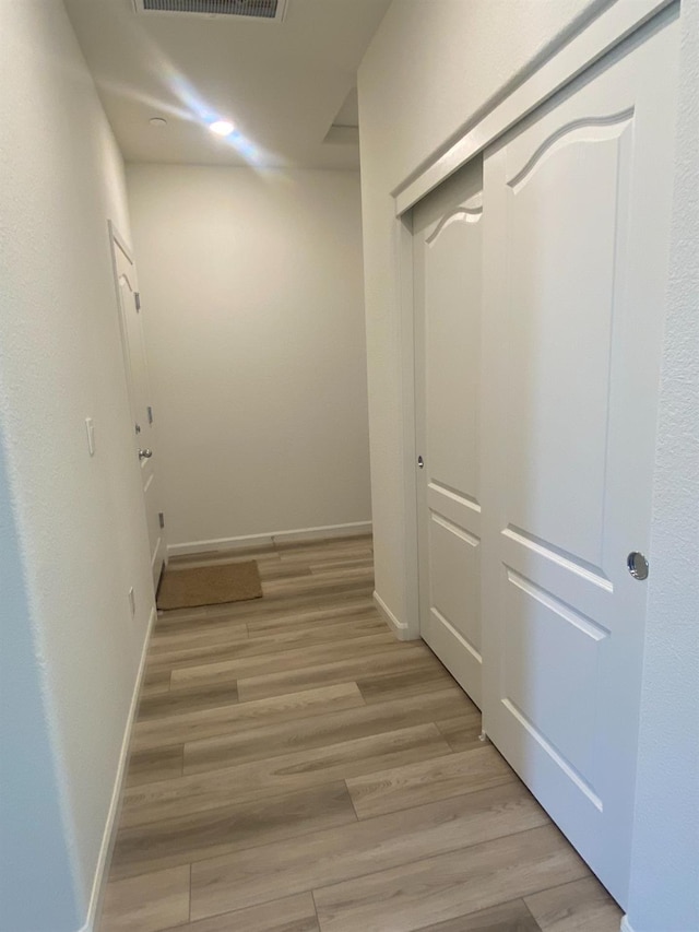 corridor with light hardwood / wood-style flooring