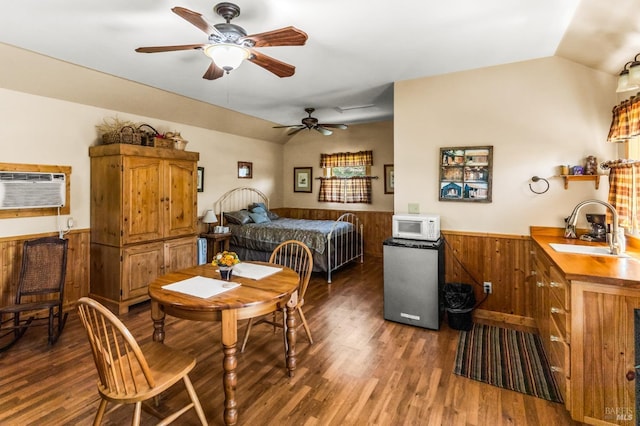 dining space featuring ceiling fan, sink, dark wood-type flooring, and lofted ceiling