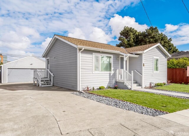 view of front of house featuring a front yard, a garage, and an outdoor structure