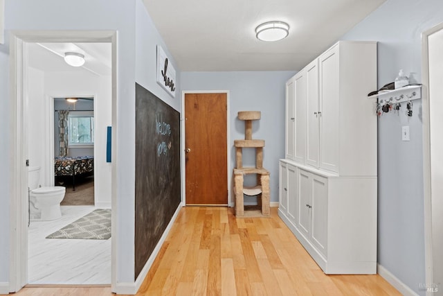 hallway featuring baseboards and light wood-style floors