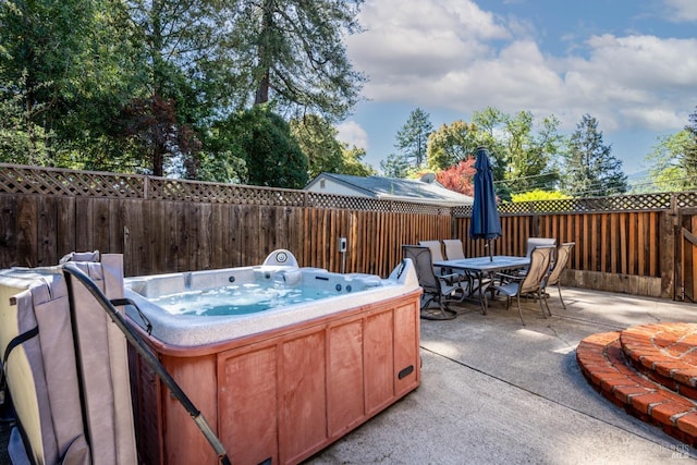 view of patio with outdoor dining space, a fenced backyard, and a hot tub