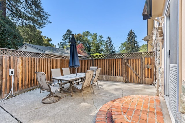 view of patio with a gate, outdoor dining area, and fence