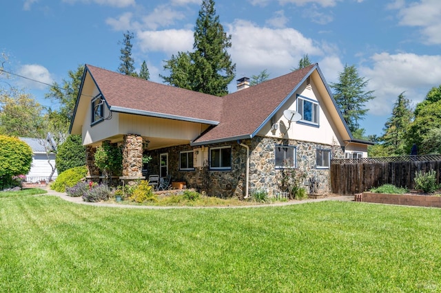 view of front of property with a chimney, a shingled roof, a front yard, and fence