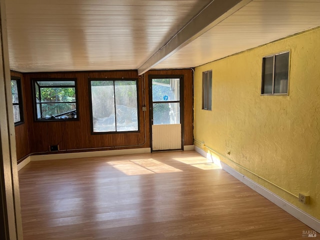 unfurnished sunroom with radiator and beamed ceiling