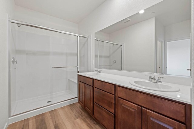 bathroom with an enclosed shower, hardwood / wood-style floors, and vanity