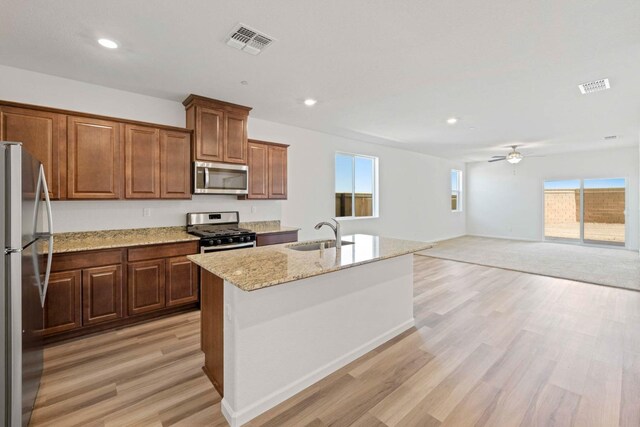 kitchen with sink, a center island with sink, a wealth of natural light, ceiling fan, and stainless steel appliances