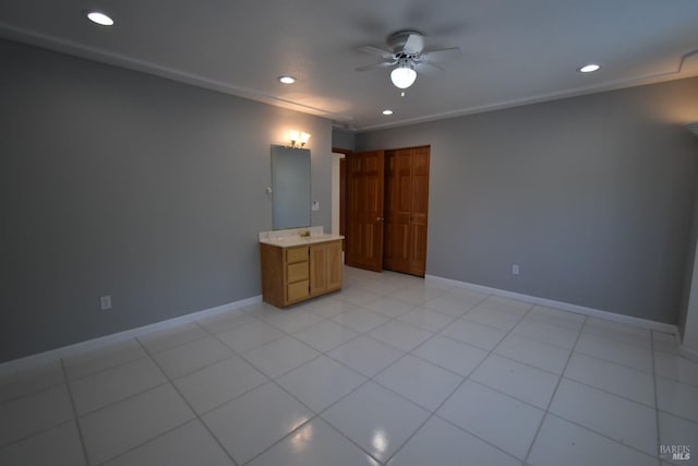 spare room featuring ornamental molding, ceiling fan, and light tile floors