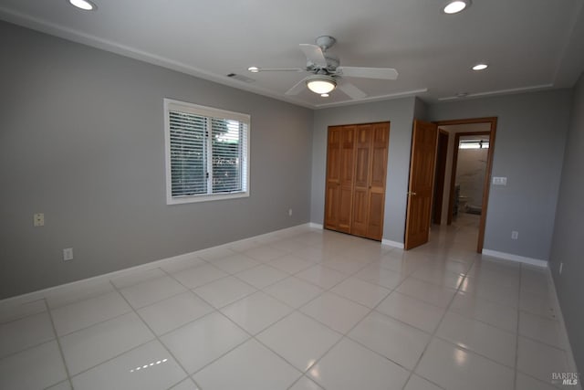 unfurnished bedroom featuring a closet, light tile flooring, and ceiling fan