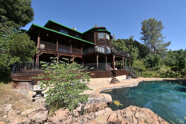 rear view of property with a swimming pool side deck