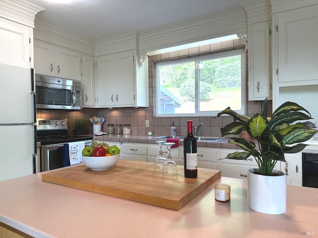 kitchen with white cabinets, stainless steel appliances, and backsplash