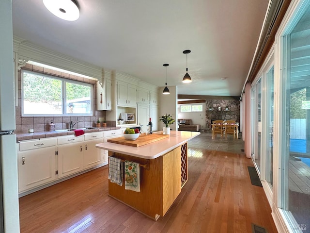4013 Lakeview Dr, Nice, CA 95464 - kitchen with white cabinets, light wood-type flooring, decorative light fixtures, and a kitchen island