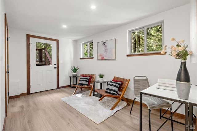 living area with light wood-type flooring, baseboards, and recessed lighting