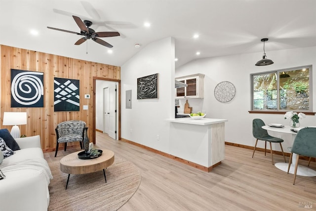 living room with baseboards, light wood-style floors, lofted ceiling, wood walls, and recessed lighting