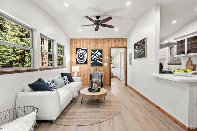 living room with baseboards, light wood-style flooring, vaulted ceiling, wood walls, and recessed lighting