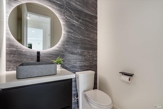 bathroom featuring tile walls, tasteful backsplash, vanity, and toilet