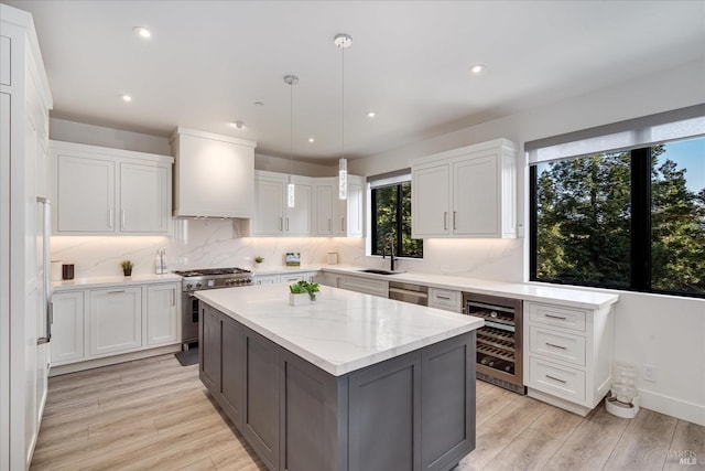 kitchen with wine cooler, appliances with stainless steel finishes, custom exhaust hood, and a kitchen island