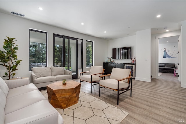 living room with wine cooler and light hardwood / wood-style flooring