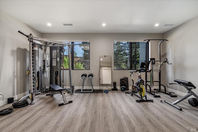 workout area with light hardwood / wood-style flooring