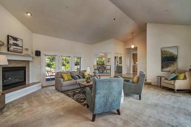 living room with a fireplace, french doors, light colored carpet, and high vaulted ceiling