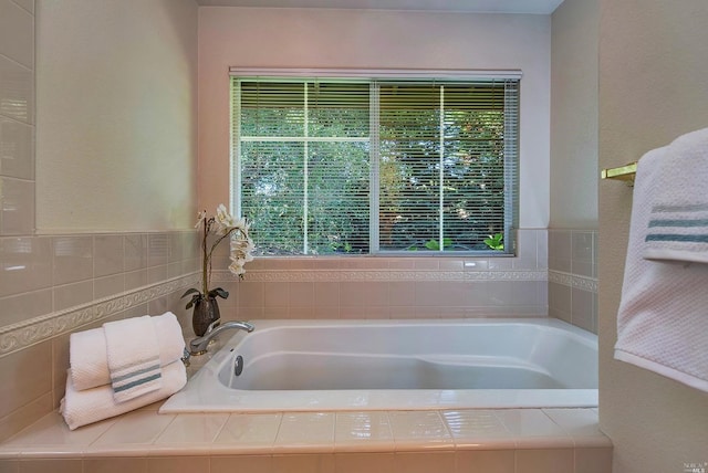 bathroom with a healthy amount of sunlight and a relaxing tiled tub