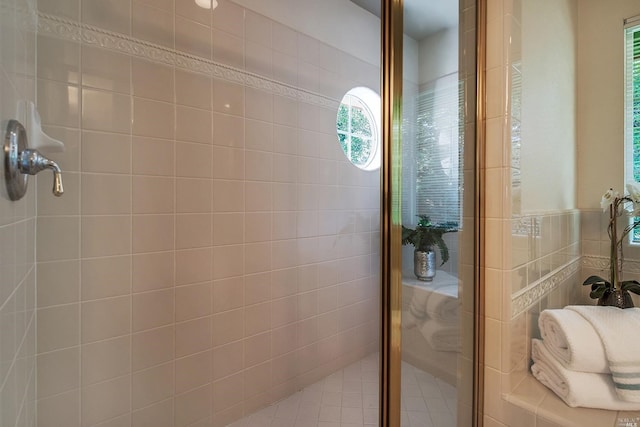 bathroom with tile walls and a shower with shower door