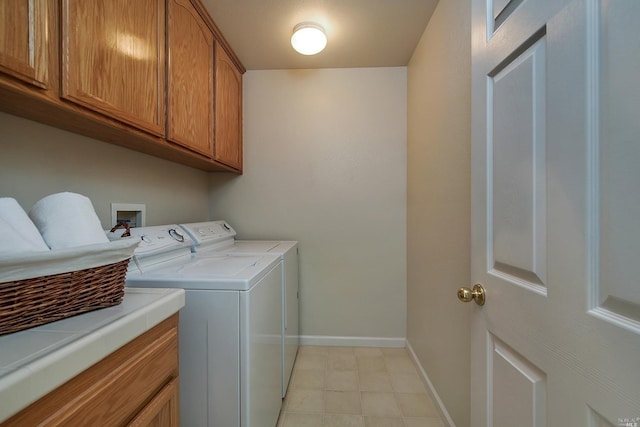 clothes washing area with independent washer and dryer and cabinets