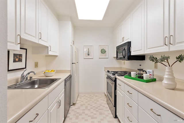 kitchen featuring appliances with stainless steel finishes, white cabinets, sink, and light tile flooring