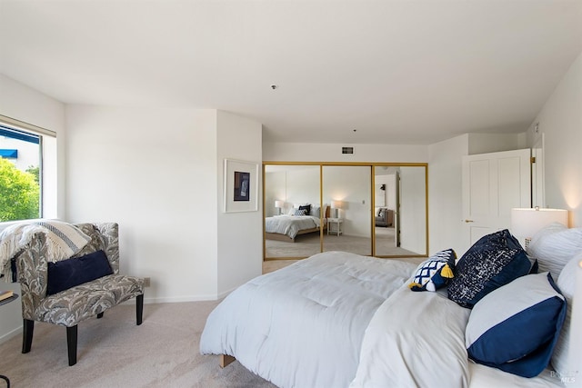 bedroom featuring light carpet and a closet