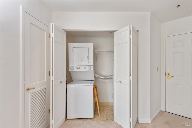 laundry area featuring stacked washer and clothes dryer and light carpet