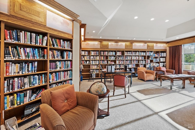 living area featuring light carpet and built in shelves