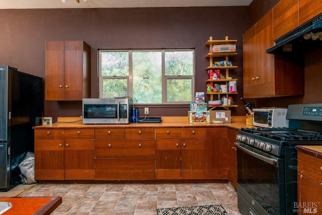 27651 Skyview Rd, Willits, CA 95490 - kitchen with gas range oven, freestanding refrigerator, stainless steel microwave, ventilation hood, and brown cabinets