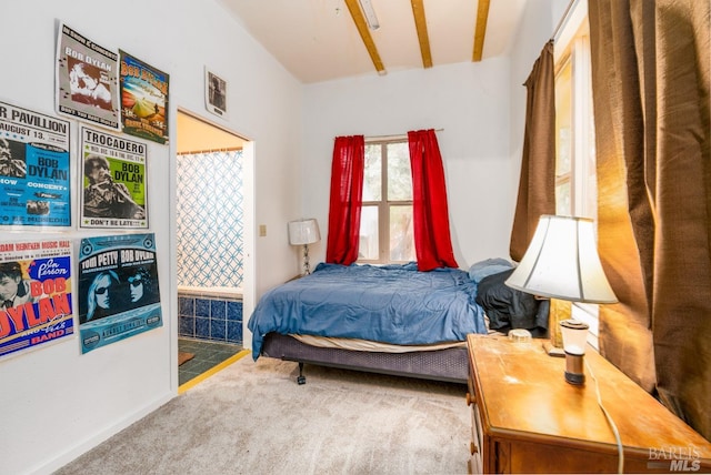 bedroom featuring beamed ceiling and carpet