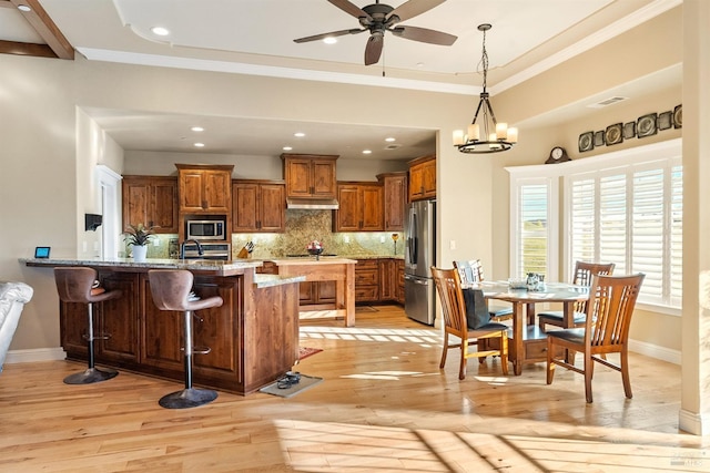 living room featuring light hardwood / wood-style floors, a wall unit AC, ceiling fan, and built in desk