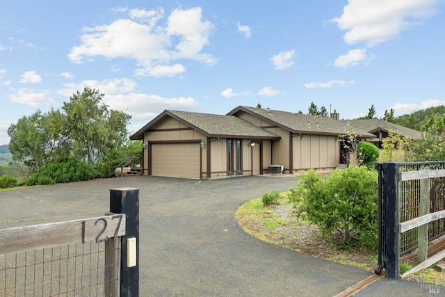 single story home with a garage and central AC unit