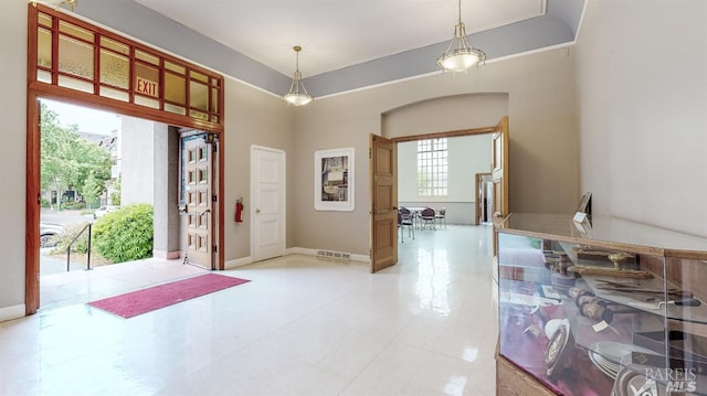 tiled foyer entrance with a wealth of natural light and a high ceiling