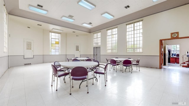 tiled dining space with a high ceiling