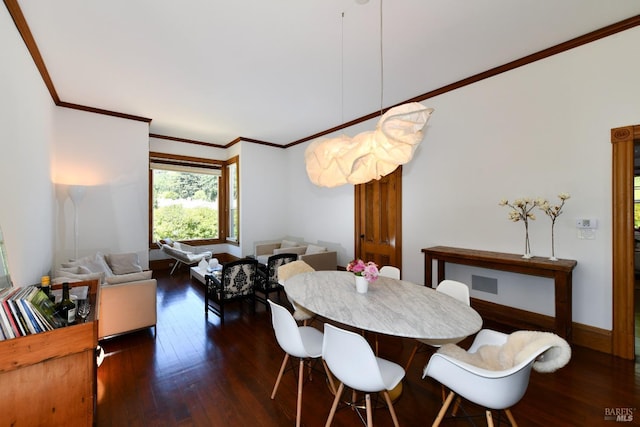 dining area with dark hardwood / wood-style floors and ornamental molding