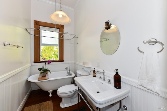 bathroom with hardwood / wood-style flooring, toilet, crown molding, and a bathing tub