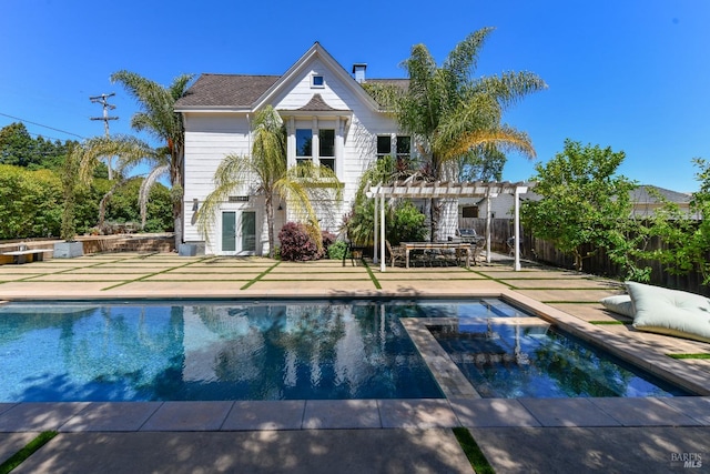 back of house with a pergola, a patio area, and a pool with hot tub