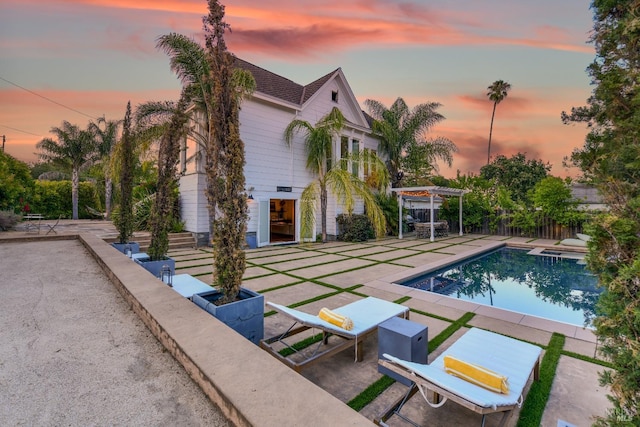 pool at dusk with a patio