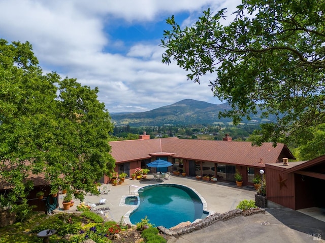 outdoor pool featuring a patio area and a mountain view