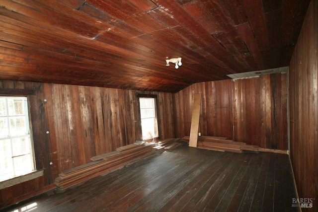 additional living space featuring vaulted ceiling, wood walls, wooden ceiling, and dark hardwood / wood-style flooring