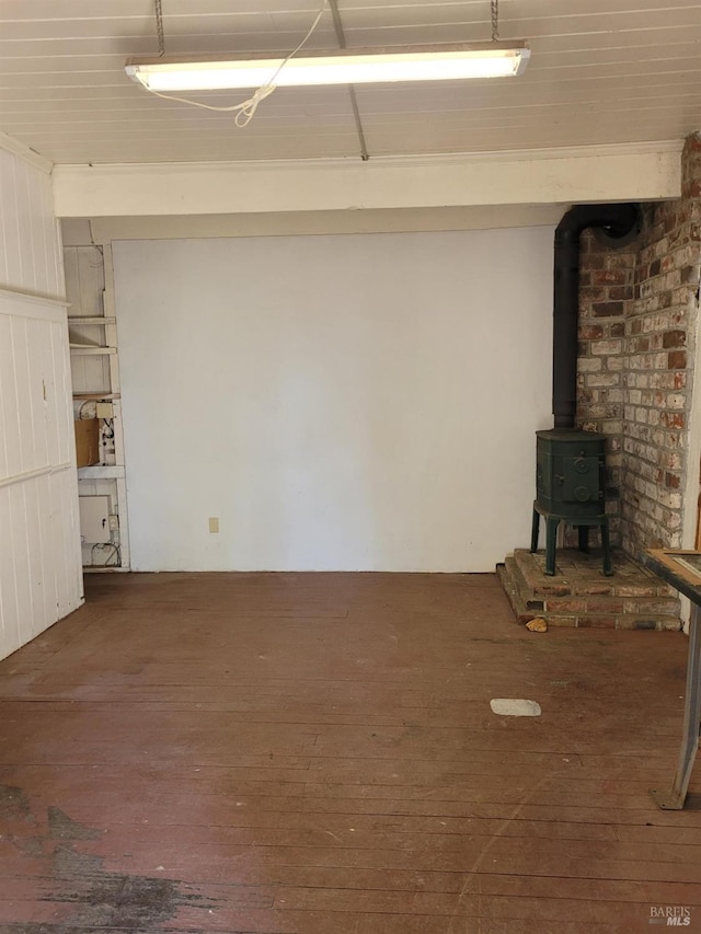 basement with a wood stove and dark hardwood / wood-style flooring