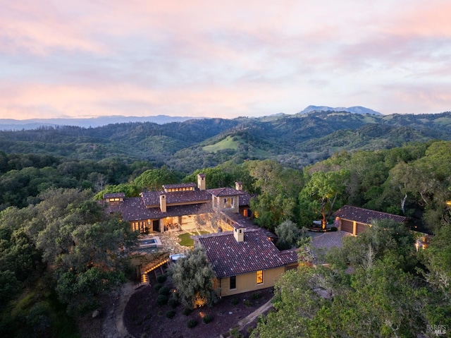 aerial view at dusk featuring a mountain view