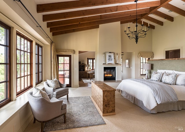 carpeted bedroom featuring beam ceiling, high vaulted ceiling, a chandelier, and a fireplace