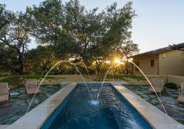 view of pool with a patio and pool water feature