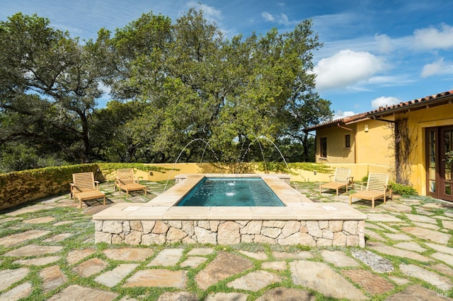 view of swimming pool featuring pool water feature and a patio