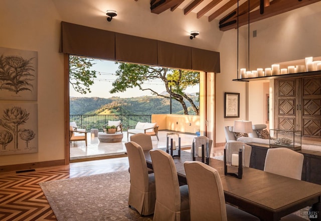 dining room featuring beamed ceiling, a mountain view, and high vaulted ceiling